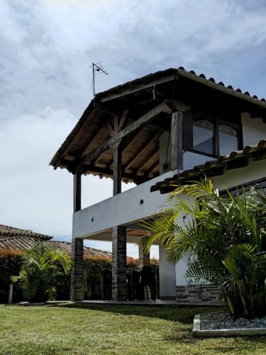 a house with a large white building at Finca Completa Carmen Viboral Naturaleza y Privacidad in Carmen de Viboral