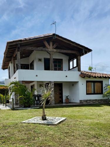a house with a palm tree in front of it at Finca Completa Carmen Viboral Naturaleza y Privacidad in Carmen de Viboral