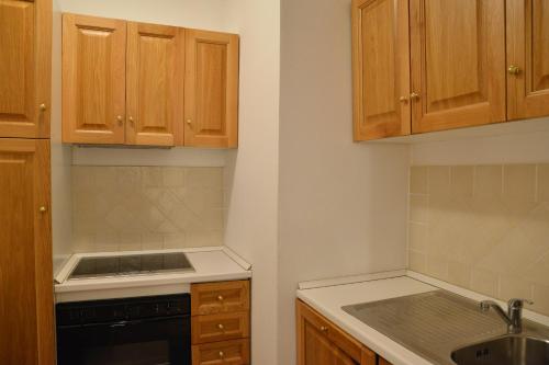 a kitchen with wooden cabinets and a stove top oven at Appartamenti Galatea in Palau