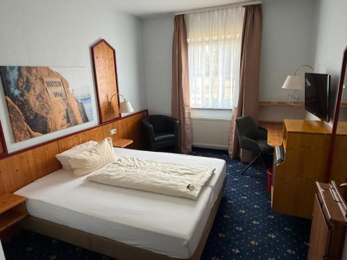 a hotel room with a bed and a desk at Hotel hArz7 in Seesen