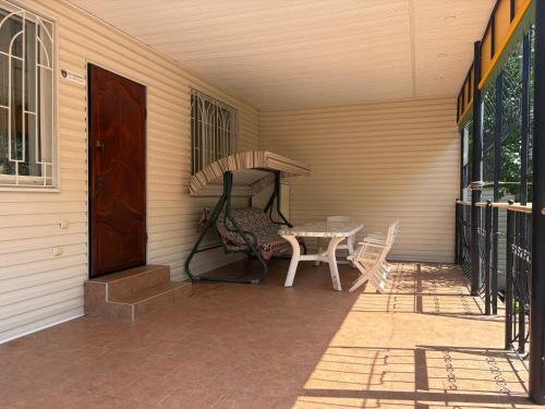 a porch with a table and an umbrella on it at Дом у моря in Odesa