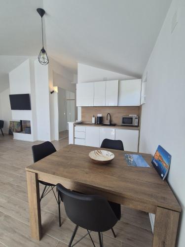 a dining room table and chairs in a kitchen at Seaview Art Studio with balcony in Kaštela