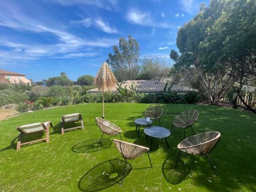 a group of chairs and tables on a lawn at La Rose des Sables suite 5 étoiles in Les Issambres