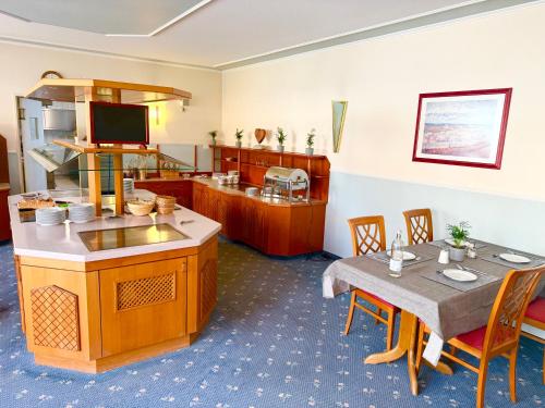 a kitchen and dining room with a table and a counter at Hotel hArz7 in Seesen