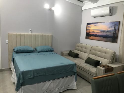 a bedroom with a bed and a couch at ESTUDIO PANORAMiCO in Florianópolis