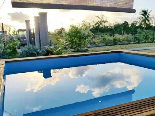 a pool with a reflection of clouds in the water at la promemade des colibris 2 in Saint-François