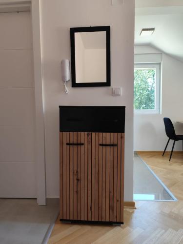 Un espejo sobre una puerta de madera en una habitación. en Raj M&M, en Vrnjačka Banja