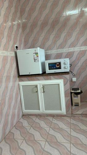 a microwave and a toaster oven on a wall at Qantab village apartment in Muscat