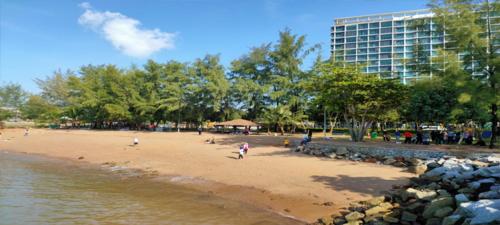 a group of people on a beach next to a building at PD D'Wharf The Bay Superior Queen Room SeaView Balcony in Port Dickson