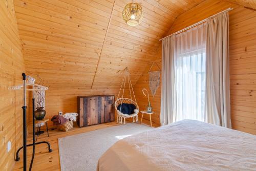 a bedroom with a bed and a window and a swing at Amara Houses in Rewal