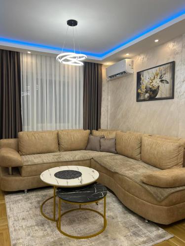 a living room with a brown couch and a table at Apartman Stoiljkovic Vrnjacka Banja in Vrnjci