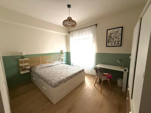 a bedroom with a bed and a desk and a window at Il Bricoccolo in Loreto