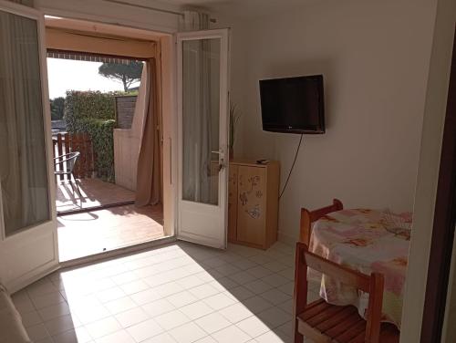 a room with a door to a balcony with a television at Marina St Cyprien in La Celle-sous-Gouzon