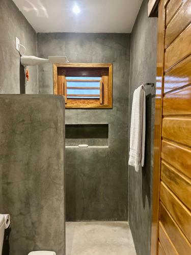 a bathroom with a shower and a window in it at Kza da Paty Preá dEla in Prea