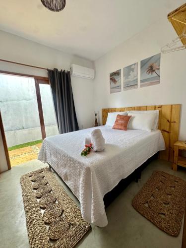 a bedroom with a large bed with white sheets and a window at Kza da Paty Preá dEla in Prea