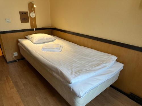 a bed with white sheets and a white pillow at Casual Housing Kemi in Kemi