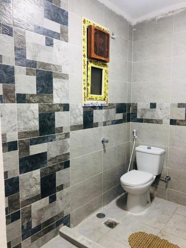 a bathroom with a toilet and a window at Two bedroom Apartment in central location in downtown Cairo in Banī Ghālib