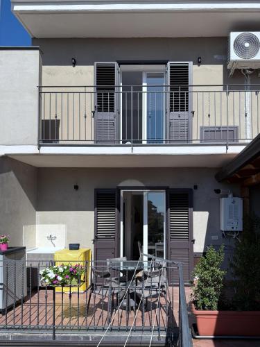 a building with a balcony with a table and a table at Albachiara House in Calatabiano