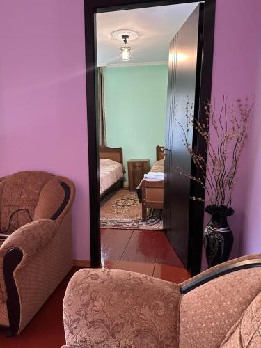 a mirror in a room with a chair and a bedroom at Guesthouse "MEGI" in Mestia