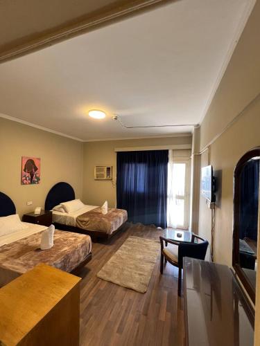 a hotel room with two beds and a table at Houres Hotel in Cairo