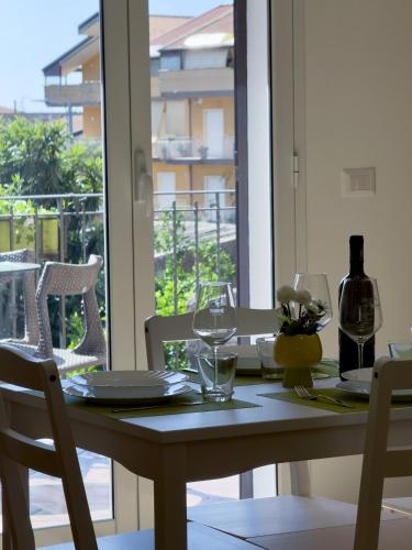 a table with glasses and a bottle of wine on a balcony at Albachiara House in Calatabiano