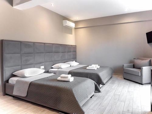 a hotel room with two beds and a chair at Endless Blue Himara in Himare
