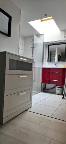 a kitchen with a sink and a red cabinet at LE TRANSAT 40m de la plage in Palavas-les-Flots