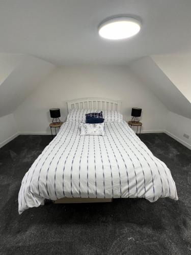 een groot wit bed in een kamer met twee tafels bij Spacious 2 bed traditional cottage in Crieff