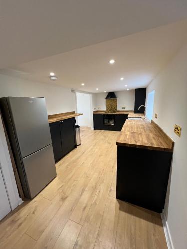 an empty kitchen with a counter and a refrigerator at Spacious 2 bed traditional cottage in Crieff