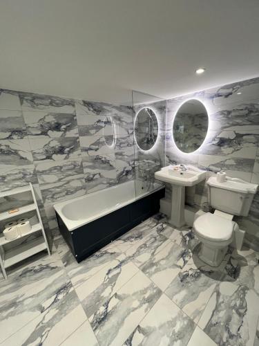 een badkamer met een wastafel, een toilet en een ligbad bij Spacious 2 bed traditional cottage in Crieff