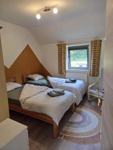 a bedroom with two beds and a window at La Clé du Circuit Spa-Francorchamps in Stavelot