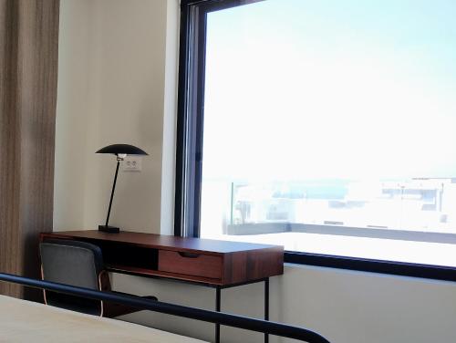 a desk with a lamp on it next to a window at Biliaba in Rhodes Town