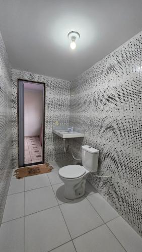 a bathroom with a toilet and a mirror at Casa Amarela no Centro in Barreirinhas