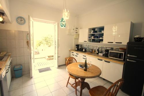 une cuisine avec une table et une porte donnant sur une terrasse. dans l'établissement Maison Andernos centre, tout à pieds!, à Andernos-les-Bains