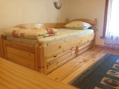 a bed with a wooden frame in a room at Tipografov View Guest House in Veliko Tŭrnovo