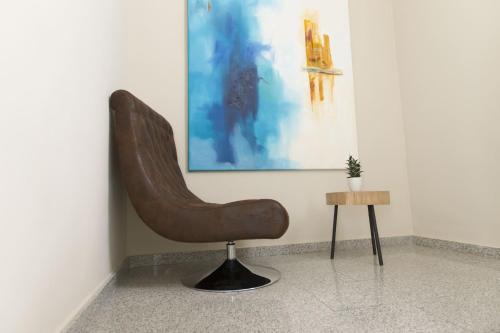 a brown chair sitting in a room next to a table at Vettonia Hotel in Merida