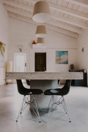 Una gran mesa de mármol con dos sillas en una habitación. en Aguglia Persa 2, en Noto