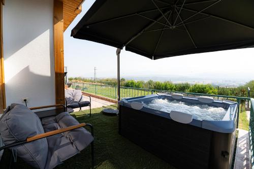 a hot tub on a balcony with an umbrella at AMAZING view, privacy and comfort - SPA Villa Krasi in Blagoevgrad