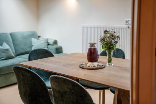 a wooden table with chairs and a vase of flowers at Gandhof - Familienzeit Gipfelglück Käsemomente in Martello