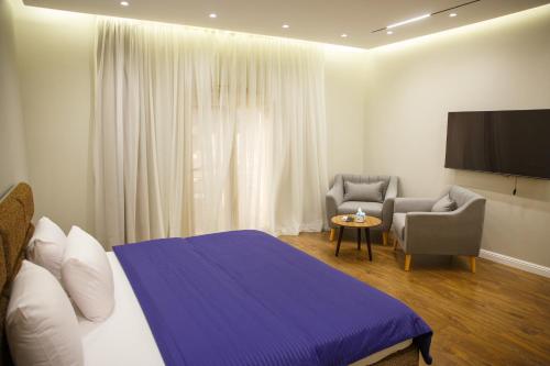 a bedroom with a bed and a tv and a chair at Munir`s residence 3 in Cairo