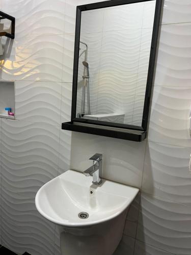 a bathroom with a sink and a mirror at REBERO RESORT Ltd in Kigali