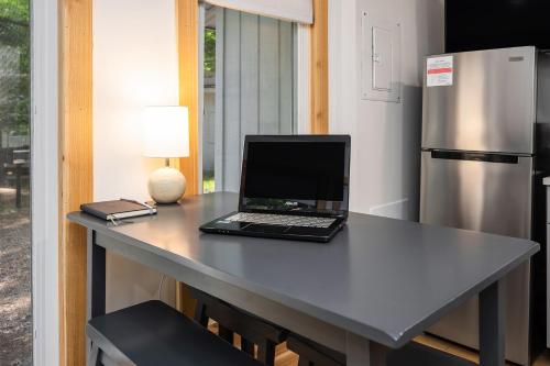 a laptop computer sitting on a table with a refrigerator at Arbutus Lake-King Suite-Pontoon Rentals in Traverse City