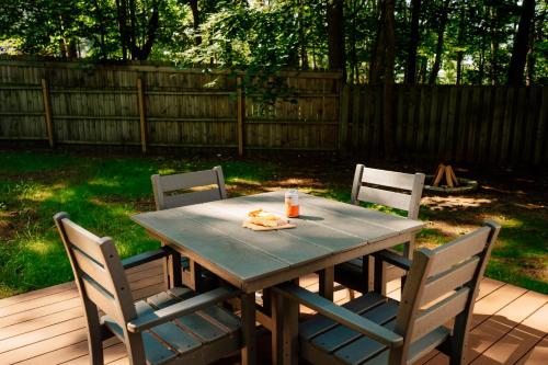 a table with three chairs and a drink on it at Arbutus Lake-King Suite-Pontoon Rentals in Traverse City