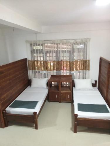 a bedroom with two beds and a wooden cabinet at Ella nature hostel in Ella
