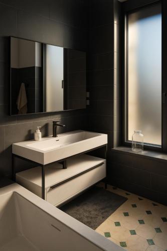 a bathroom with a sink and a tub and a mirror at Maison de Maître en Champagne in Vitry-le-François