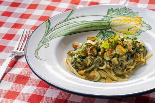 a plate of food with pasta and vegetables on a table at Capo la Gala Hotel&Wellness in Vico Equense