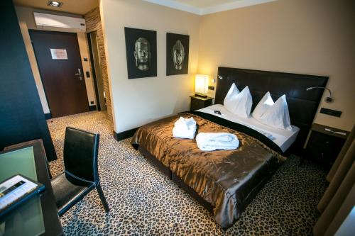 a hotel room with a bed with two towels on it at Hotel Seebrunn am Wallersee in Henndorf am Wallersee