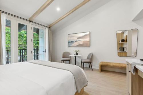 a bedroom with a bed and a table with chairs at Casa Riviera - Boutique Suites in Downtown Santa Barbara in Santa Barbara