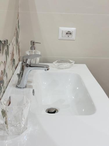 a white bathroom sink with a chrome faucet at Albachiara House in Calatabiano