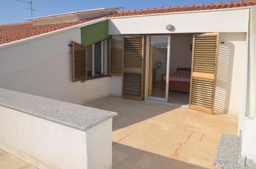 a balcony with wooden shutters on a house at Taormina Bay Lucia's House 3 in Nizza di Sicilia